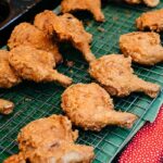 Delicious crispy fried chicken displayed at a street market stall, perfect for a tasty meal.