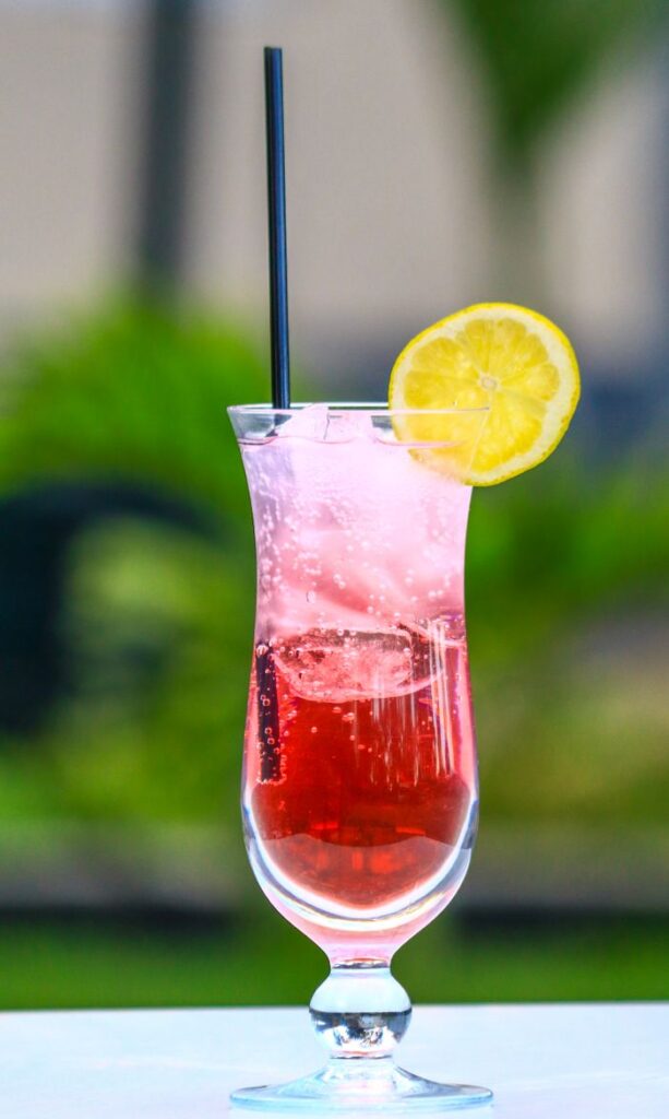 Chilled pink lemonade cocktail with a lemon slice, perfect for summer refreshment.
